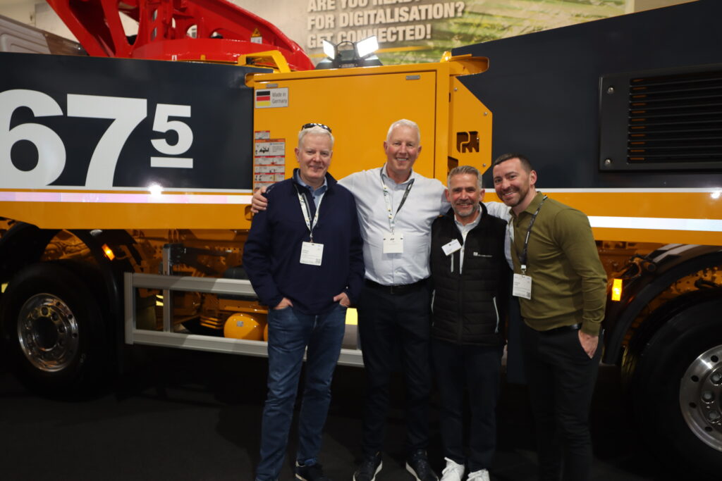 Camfaud Team stood in front of a Putzmeister mobile concrete pump at bauma 2025